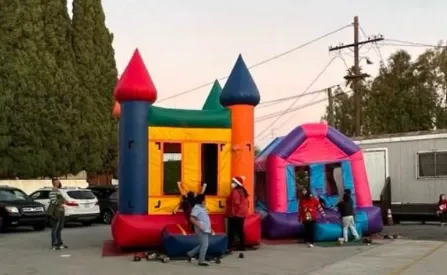 Two inflatable bounce castles set up outdoors, with our crew finishing the setup